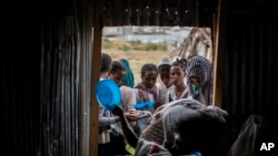Des Tigréens font la queue pour recevoir de la nourriture donnée par des résidents locaux dans un centre d'accueil pour personnes déplacées à Mekele, dans la région du Tigré au nord de l'Éthiopie, le 9 mai 2021.