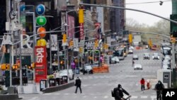 Peatones y ciclistas circulan por Times Square, un icónico lugar de Nueva York que ahora pareciera una escena de una ciudad fantasmal.