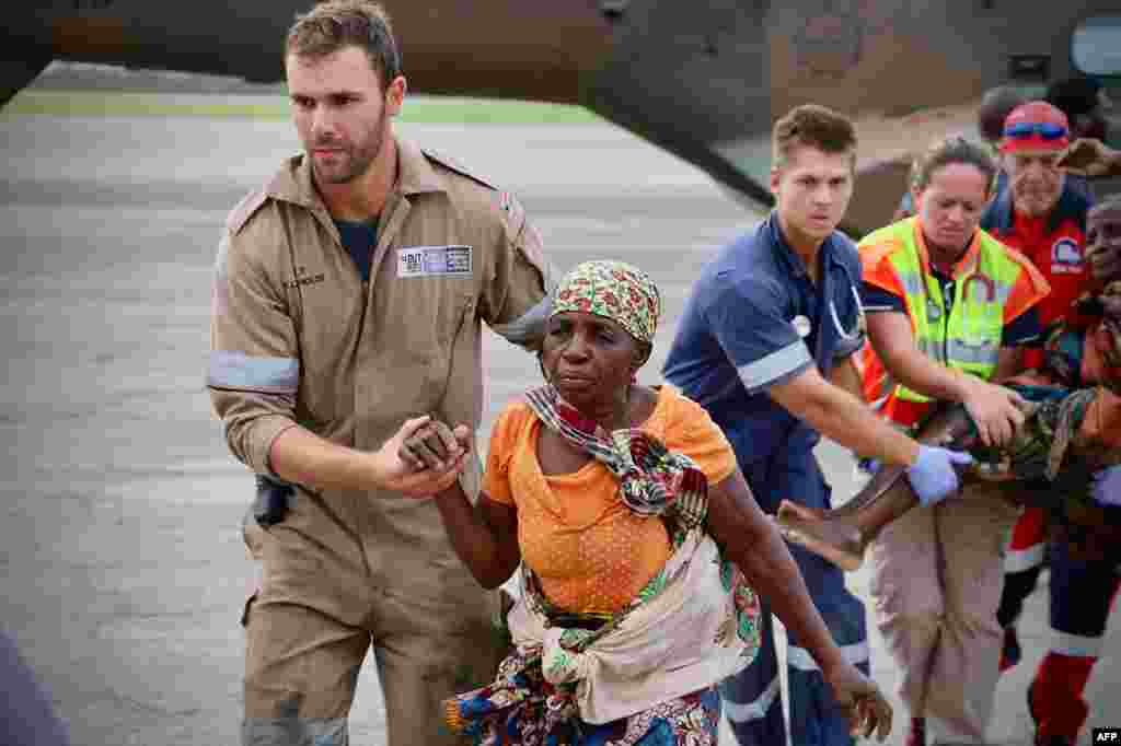 Pessoas são ajudadas no aeroporto da cidade da Beira, no centro de Moçambique, a 19 de Março, 2019, depois da região ter sido afectada pelo ciclone Idai