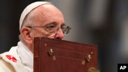 El papa besa la Biblia durante la misa del 1 de enero en la Basílica de San Pedro en el Vaticano.