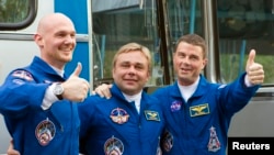 The International Space Station (ISS) crew members (L-R) Alexander Gerst of Germany, Maxim Surayev of Russia and Reid Wiseman of the U.S. pose before going from a hotel for a final pre-launch preparation at the Baikonur cosmodrome, May 28, 2014.