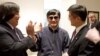 In this photo released by the US Embassy Beijing Press Office, blind lawyer Chen Guangcheng, center, holds hands with U.S. Ambassador to China Gary Locke, right, as U.S. State Department Legal Advisor Harold Koh, left, applauds, before leaving the U.S. em