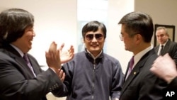 In this photo released by the US Embassy Beijing Press Office, blind lawyer Chen Guangcheng, center, holds hands with U.S. Ambassador to China Gary Locke, right, as U.S. State Department Legal Advisor Harold Koh, left, applauds, before leaving the U.S. em