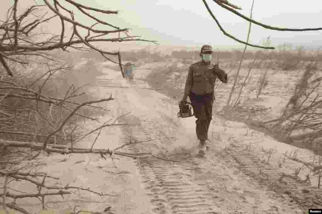 A police officer walks through ash during rescue operations after the Mount Sinabung eruption, near Suka Meriah village in Karo, North Sumatra province Feb. 2, 2014.