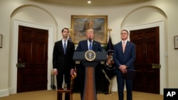美國總統川普在白宮提出一項減少移民人數的立法提案，國會參議員湯姆·科頓（左）和戴維·帕度站立在兩邊。 （2017年8月2日）