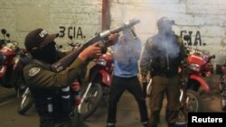 Un policía antimontines dispara gas lacrimógeno durante una protesta de la policía contra el gobierno de Evo Morales, en demanda de incrementos salariales.
