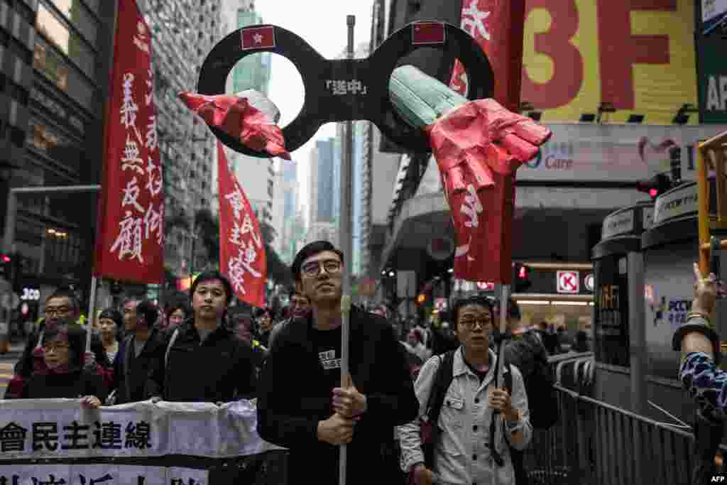 Protesters march along a street during a rally in Hong Kong to protest against the government&#39;s plans to approve extraditions with mainland China, Taiwan and Macau.