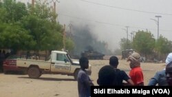 Quelques personnes regardent au loin le lieu d’une attaque-kamikaze dans la région de Gao, dans le centre-nord du Mali, 1er juillet 2018. (VOA/ Sidi Elhabib Maiga)