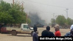 Quelques personnes regardent au loin le lieu d’une attaque-kamikaze dans la région de Gao, dans le centre-nord du Mali, 1er juillet 2018. (VOA/ Sidi Elhabib Maiga)