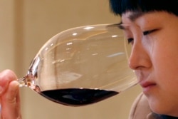 A woman smells red wine during A wine-tasting event in Beijing April 18, 2007. (REUTERS/Claro Cortes IV)