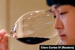 A woman smells red wine during A wine-tasting event in Beijing April 18, 2007. (REUTERS/Claro Cortes IV)