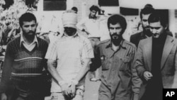 Một trong 60 con tin Mỹ, bị bịt mắt và trói, được đưa ra trước đám đông bên ngoài Đại sứ quán Mỹ tại Tehran (ảnh tư liệu ngày 9/11/1979)