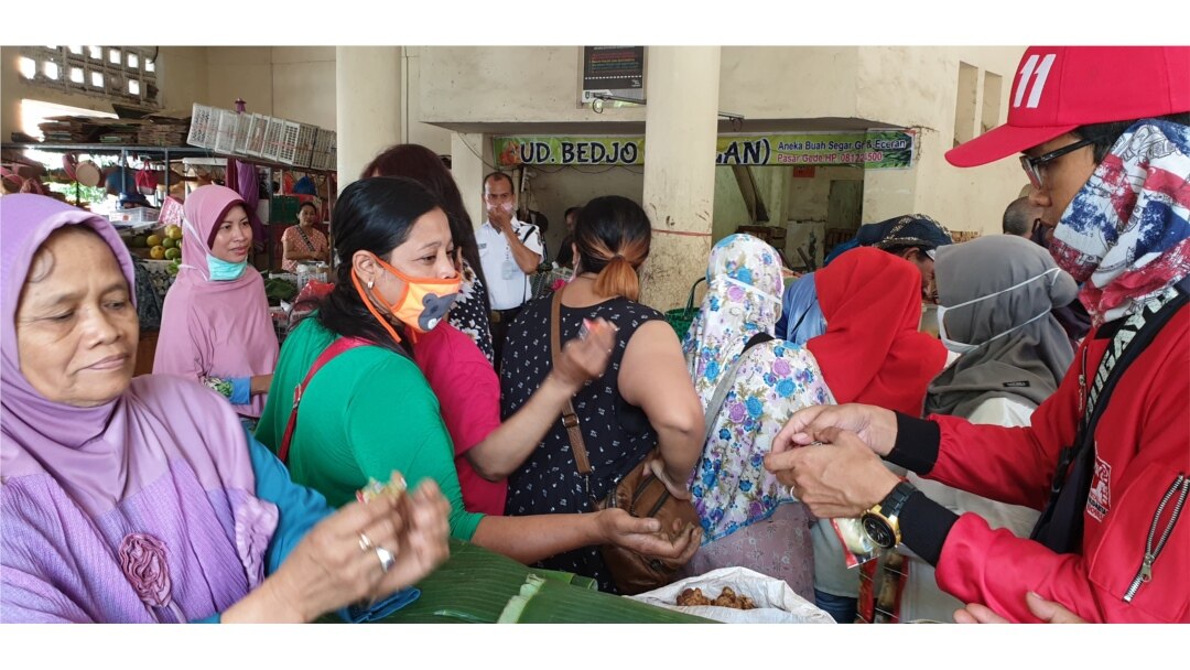 Relawan membagikan sabun cuci tangan kepada pedagang pasar Gedhe Solo, 21 Maret 2020. (Foto: VOA/ Yudha Satriawan)