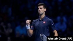 Novak Djokovic célébrant sa victoire contre Milos Raonic lors du tournoi mondial de l' ATP à Londres, Angleterre le 15 Novembre 2016 (AP Photo/Alastair Grant)