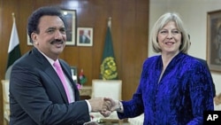 Visiting British Home Secretary Theresa May exchanges copies of agreements regarding bilateral issues - including cooperation in the war against terrorism - with Pakistan's Interior Minister Rehman Malik in Islamabad, Pakistan, Oct 26, 2010 (File Photo)