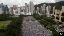 Tens of thousands of residents gather to march in downtown streets during an annual pro-democracy protest in Hong Kong Tuesday, July 1, 2014. Hong Kong residents began marching through the streets of the former British colony to push for greater democracy
