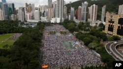 Tens of thousands of residents gather to march in downtown streets during an annual pro-democracy protest in Hong Kong Tuesday, July 1, 2014. Hong Kong residents began marching through the streets of the former British colony to push for greater democracy