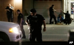 Dallas police detain a driver after several police officers were shot in downtown Dallas on July 7, 2016. Snipers apparently shot police officers during protests and some of the officers are dead, the city's police chief said in a statement.