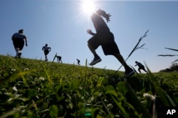 Recruits and instructors from the New Orleans Police Department academy run through drills on a levee along Lake Pontchartain in New Orleans, March 15, 2017. Temperatures were in the 60s.