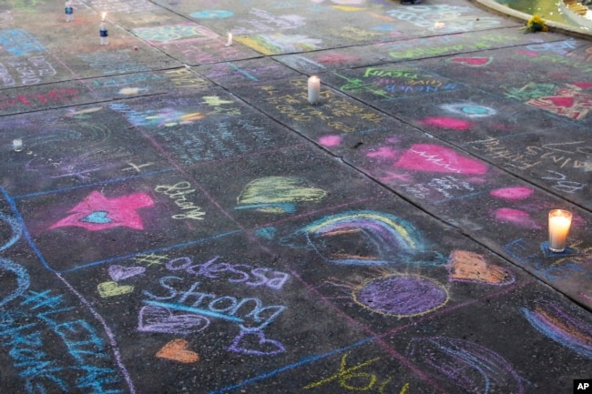 Una acera pintada con mensajes de tiza en Odessa, Texas, en el lugar donde se realizó un servicio funeral por las víctimas de un tiroteo la víspera. AP/Sue Ogrocki.
