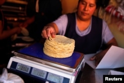 An employee weighs tortillas outside Granada market in Mexico City, Mexico, Jan. 10, 2017.