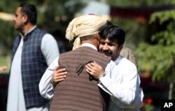 Warga saling menyambut setelah salat Ied di istana kepresidenan di Kabul, Afghanistan.