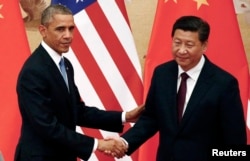 ປະທານາທິບໍດີ ສະຫະລັດ ທ່ານ Barack Obama (ຊ້າຍ) ຈັບມືກັບ ປະທານປະເທດຈີນ ທ່ານ Xi Jinping ໃນລະຫວ່າງ ກອງປະຊຸມຖະແຫລງ ຂ່າວ ຢູ່ທີ່ ຫໍສາລາ ປະຊາຊົນ ໃນປັກກິ່ງ, ວັນທີ 12 ພະຈິກ 2014.