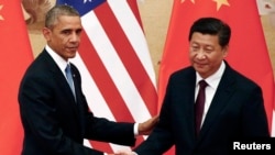 FILE - U.S. President Barack Obama (L) shakes hands with China's President Xi Jinping during a joint news conference at the Great Hall of the People in Beijing, Nov. 12, 2014.