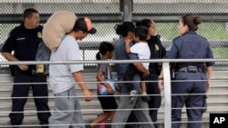 Arrivée de familles de migrants, escortés par la police des frontières des États-Unis, le 21 juin 2018 à Hildalgo, au Texas.