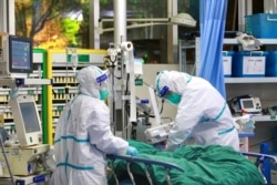Medical staff in protective suits treat a patient with pneumonia caused by the new coronavirus at the Zhongnan Hospital of Wuhan University, in Wuhan, Hubei province, China January 28, 2020.