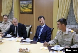 FILE - Russian President Vladimir Putin (2-L) and Syrian President Bashar al-Assad (2-R) meet with servicemen as they visit the Hmeymim air base in Latakia Province, Syria, Dec. 11, 2017.