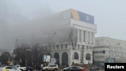 FILE - A view shows smoke billowing from inside a building that houses several TV and radio stations following the protests triggered by fuel price increase, in Almaty, Kazakhstan, Jan. 6, 2022. 