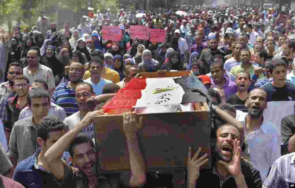 Supporters of Egypt's ousted President Mohamed Morsi march carry a coffin, covered with a national flag, of a protester who was killed during Wednesday' clashes in Cairo, August 16, 2013.