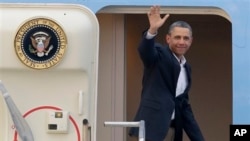 President Barack Obama waves from Air Force One, February 18, 2013, as he departs West Palm Beach, where he spent the Presidents Day weekend playing golf.