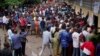 Hundreds of Congolese voters who have been waiting at the St. Raphael school in the Limete district of Kinshasa Dec. 30, 2018, storm the polling stations after the voters listings were finally posted five hours after the official start of voting. 