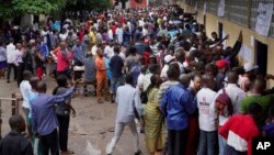 Hundreds of Congolese voters who have been waiting at the St. Raphael school in the Limete district of Kinshasa Dec. 30, 2018, storm the polling stations after the voters listings were finally posted five hours after the official start of voting. 