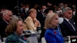 德国总理默克尔（中）2021年11月1日在苏格兰格拉斯哥举行的联合国气候峰会开幕式上。来自世界各地的领导人参加此次峰会制定应对全球变暖共同挑战的愿景。（美联社照片/Alberto Pezzali）