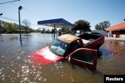 FILE - An abandoned truck lies in submerged waters after Hurricane Matthew hit Lumberton, North Carolina, Oct. 9, 2016.