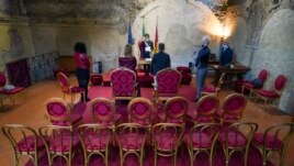 City Hall Official Mario Donati, center, marries bride Tatiana Datolla, center-left, and groom Armando De Rosa, at the deconsecrated Santa Maria in Tempulo church, in Rome, Saturday, April 11, 2020. (AP Photo/Andrew Medichini)