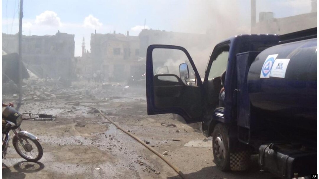 This image taken in Wednesday, Sept. 30, 2015 posted on the Twitter account of Syria Civil Defence, also known as the White Helmets, a volunteer search and rescue group, shows the aftermath of an airstrike in Talbiseh, Syria.