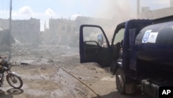 This image taken in Wednesday, Sept. 30, 2015 posted on the Twitter account of Syria Civil Defence, also known as the White Helmets, a volunteer search and rescue group, shows the aftermath of an airstrike in Talbiseh, Syria.