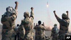 FILE - Members of the Iranian Revolutionary Guard celebrate after launching a missile during maneuvers in an undisclosed location in Iran, July 3, 2012.