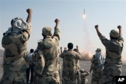 FILE - In this photo released by the Islamic Republic News Agency (IRNA), members of the Iranian Revolutionary Guard celebrate after launching a missile during their maneuver in an undisclosed location in Iran, July 3, 2012.