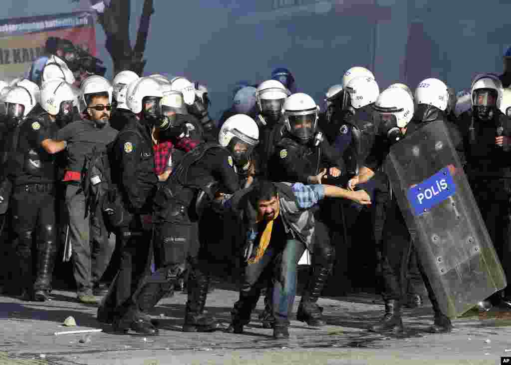 Turkish riot police detain protesters in Ankara after using tear gas to disperse a demonstration against Turkey's policy in Syria as fighting intensified between Syrian Kurds and the militants of Islamic State group in Kobani, Syria. 