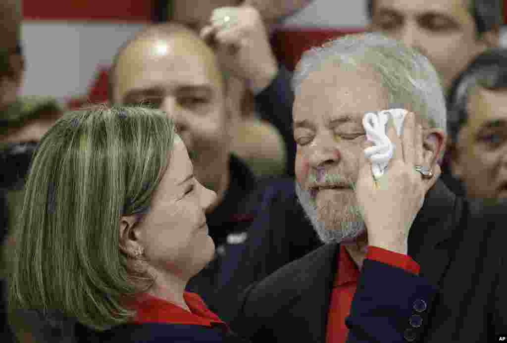 Brazillian Worker's Party president, Sen. Gleisi Hoffmann, wipes sweat from the face of former Brazilian president Luiz Inacio Lula da Silva at the end of a brief speech he delivered to media and supporters at the party's headquarters in Sao Paulo. Silva launched a defiant public defense after being convicted of corruption and money laundering, accusing his political opponents of trying to prevent him from becoming president again.