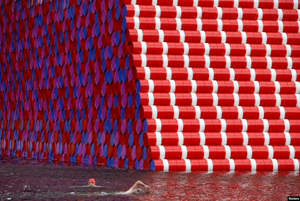 크리스토 앤 장 클라우드(Christo and Jeanne-Calude)의 신작 '런던 마스타바(The London Mastabe)'가 런던 하이드파크 내 서펀틴강에 전시된 가운데 수영선수들이 전시 작품 앞에서 수영하고 있다. 