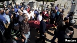 The body of Reuven Aviram, 51, one of two people killed Nov. 19 in a Palestinian stabbing attack in Tel Aviv, is carried by friends and relatives during his funeral in Ramle, Israel, Nov. 20, 2015.