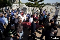 The body of Reuven Aviram, 51, one of two people killed Nov. 19 in a Palestinian stabbing attack in Tel Aviv, is carried by friends and relatives during his funeral in Ramle, Israel, Nov. 20, 2015.