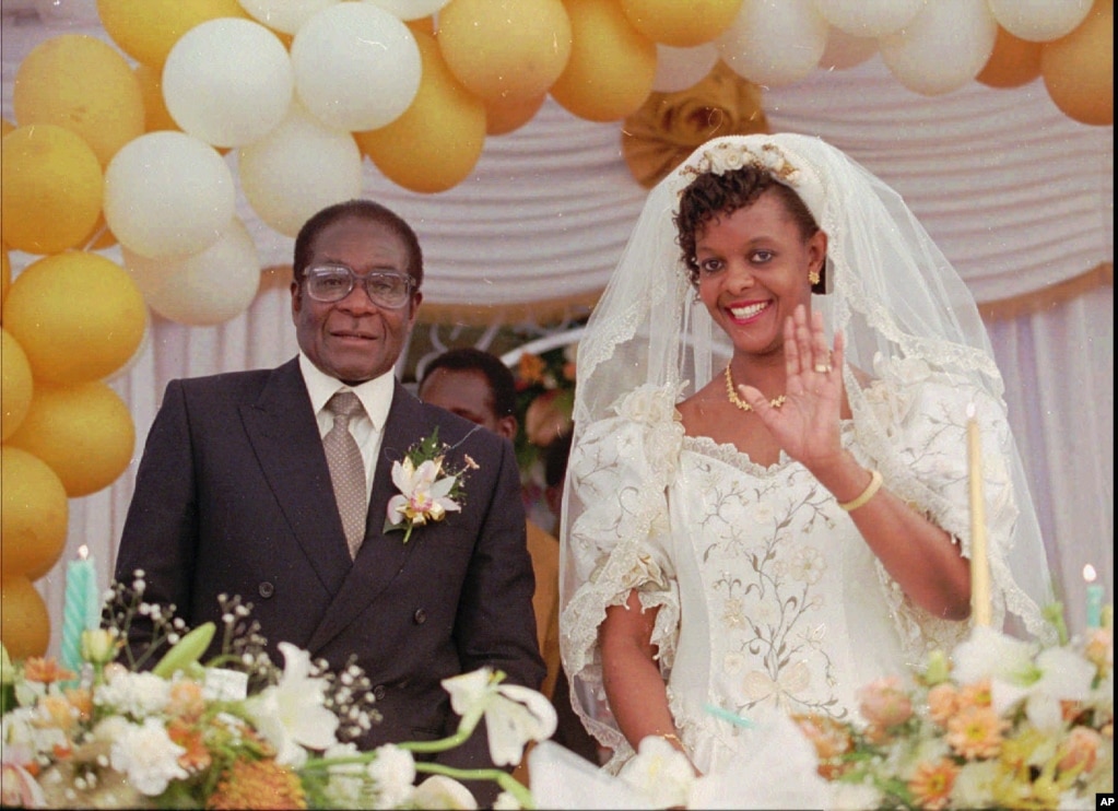 Grace Marufu, the new bride of Zimbabwean President Robert Mugabe, right, waves at guests Aug. 17, 1996, after their wedding ceremony at the Kutama catholic mission 42 miles, (80kms )west of Harare. (AP Photo)