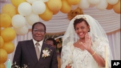 Grace Marufu, the new bride of Zimbabwean President Robert Mugabe, right, waves at guests Saturday, Aug. 17, 1996.